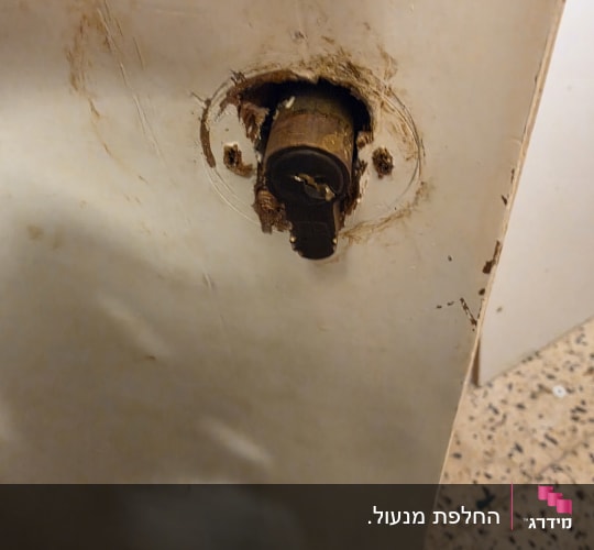 צילינדר מנעול בולט מתוך דלת עץ שבורה במהלך תיקון או פריצה